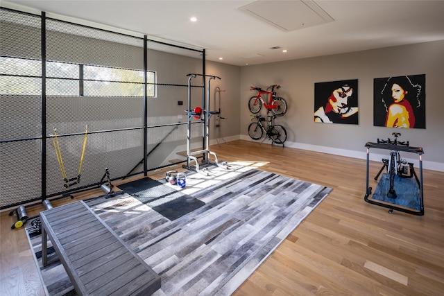 workout area featuring baseboards, attic access, recessed lighting, and wood finished floors