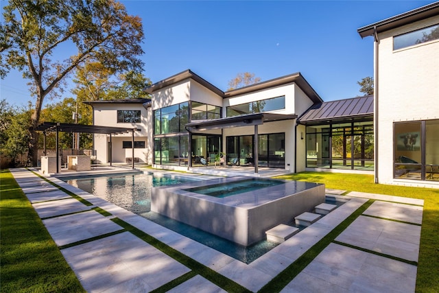 pool featuring a lawn, a patio, an in ground hot tub, and an outdoor kitchen