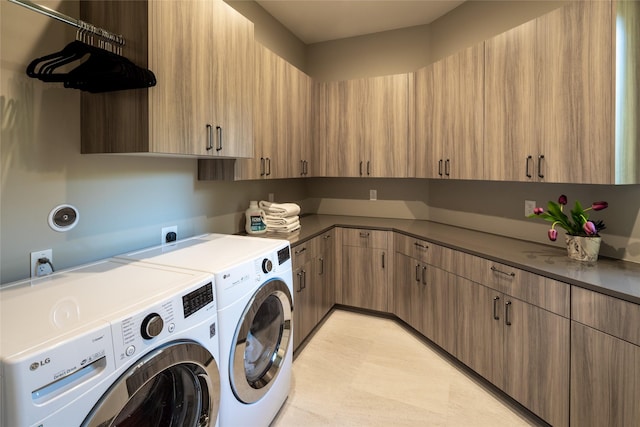 clothes washing area featuring cabinet space and washing machine and clothes dryer