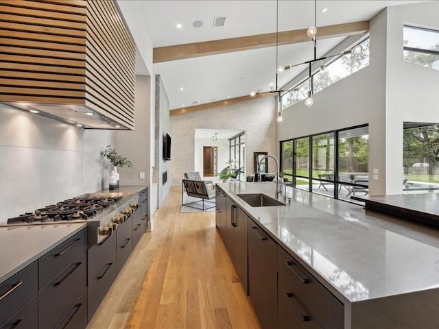 kitchen featuring a sink, a high ceiling, stainless steel gas stovetop, and modern cabinets