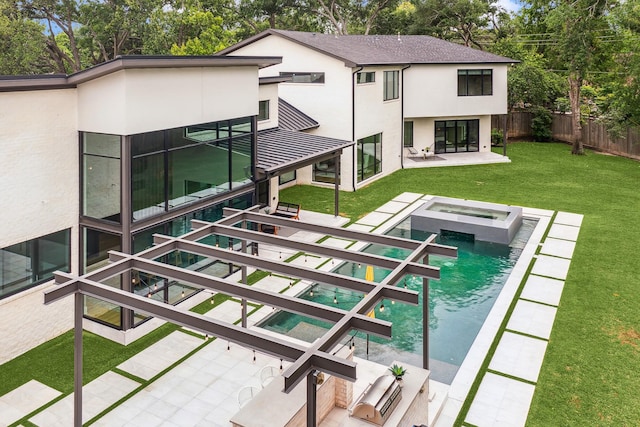 rear view of property with a patio, a fenced backyard, stucco siding, an in ground hot tub, and a yard