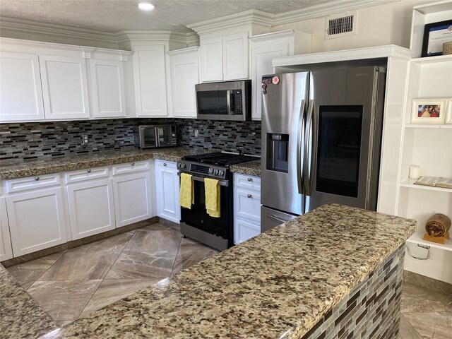 1319 Cherry Spring Dr, Houston, TX 77038 - kitchen featuring stone countertops, white cabinetry, appliances with stainless steel finishes, visible vents, and decorative backsplash