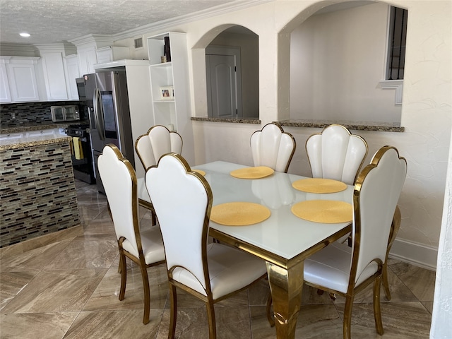 1319 Cherry Spring Dr, Houston, TX 77038 - dining space featuring a textured ceiling, marble finish floor, ornamental molding, and a toaster