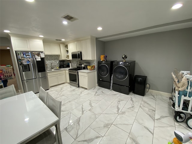 1319 Cherry Spring Dr, Houston, TX 77038 - kitchen with visible vents, marble finish floor, tasteful backsplash, appliances with stainless steel finishes, and washer and clothes dryer