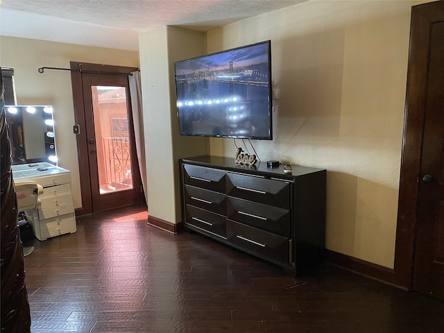 1319 Cherry Spring Dr, Houston, TX 77038 - bedroom with dark wood-style floors, baseboards, access to exterior, and a textured ceiling