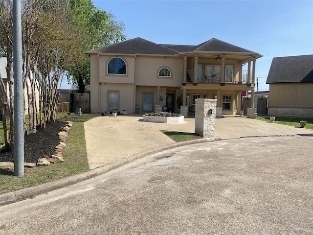 1319 Cherry Spring Dr, Houston, TX 77038 - view of front of house with stucco siding, a balcony, driveway, a ceiling fan, and fence private yard