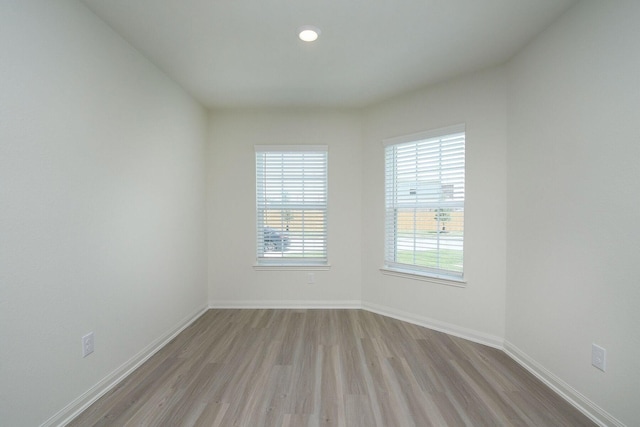empty room with baseboards and wood finished floors