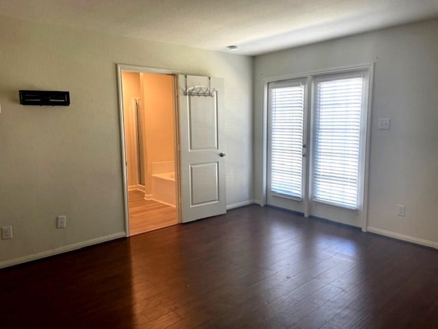 interior space featuring dark wood-style flooring, baseboards, and multiple windows