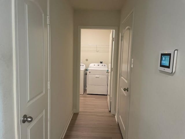 hall with baseboards, washing machine and dryer, and wood finished floors