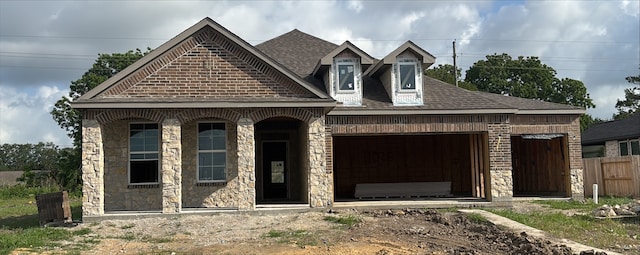 11026 Youngquist Dr, Mont Belvieu, TX 77535 - french country style house featuring a garage, stone siding, and a shingled roof