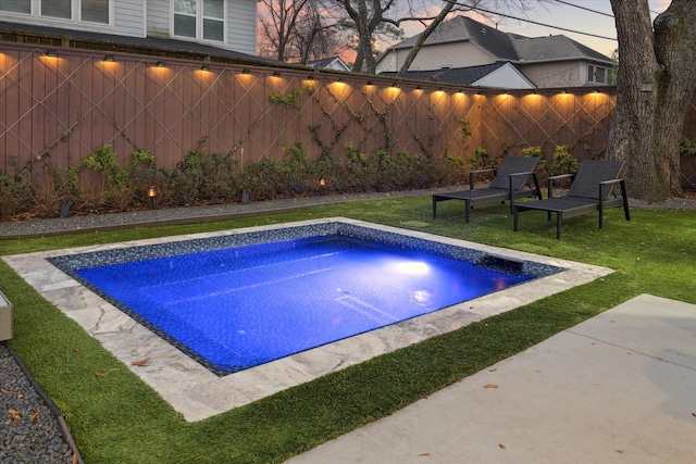 view of pool featuring fence and a lawn