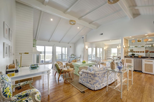living room featuring light wood-style floors, beamed ceiling, high vaulted ceiling, a chandelier, and recessed lighting