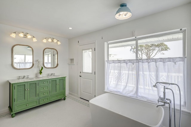 full bath with baseboards, healthy amount of natural light, double vanity, and recessed lighting