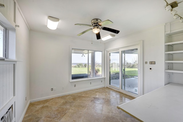 unfurnished dining area with a ceiling fan, ornamental molding, and baseboards