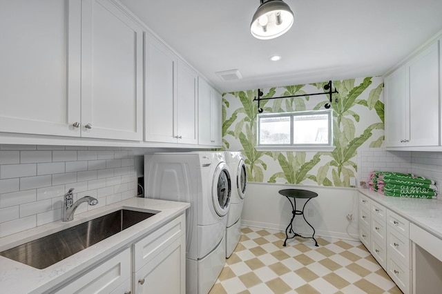 laundry area with washer and clothes dryer, cabinet space, wallpapered walls, light flooring, and baseboards