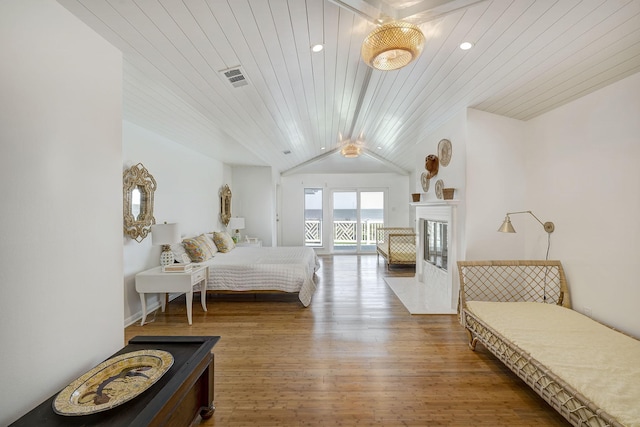 bedroom featuring lofted ceiling, wood finished floors, access to exterior, wood ceiling, and a fireplace with flush hearth