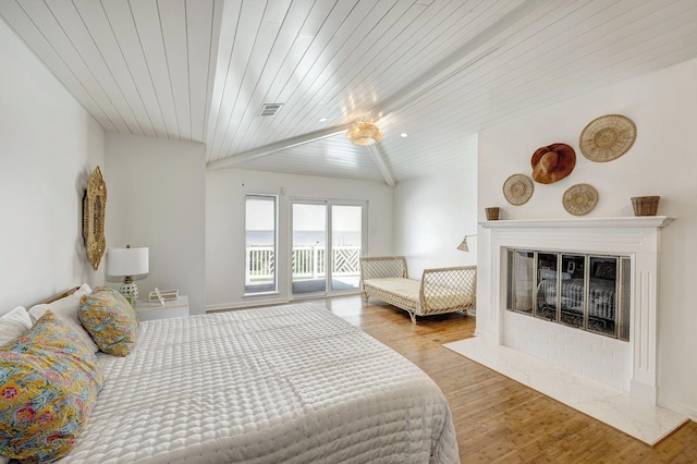 bedroom with access to exterior, wood finished floors, wooden ceiling, a fireplace with flush hearth, and lofted ceiling
