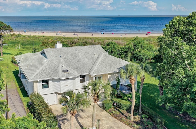 aerial view of property and surrounding area with waterfront with a beach