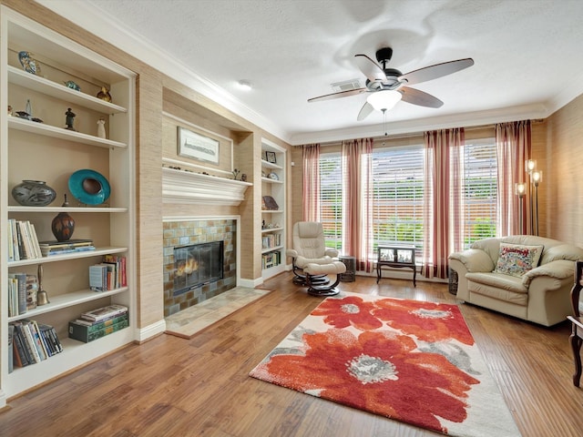 15415 Parkwood Way, Houston, TX 77059 - living room featuring a tiled fireplace, a textured ceiling, crown molding, and ceiling fan