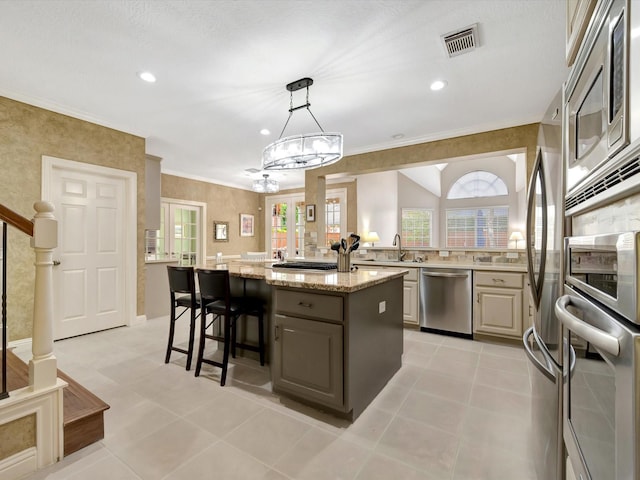 15415 Parkwood Way, Houston, TX 77059 - kitchen with visible vents, a sink, appliances with stainless steel finishes, a breakfast bar, and light stone countertops