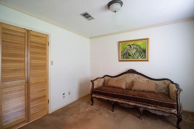 sitting room with a textured ceiling, carpet, visible vents, and ornamental molding