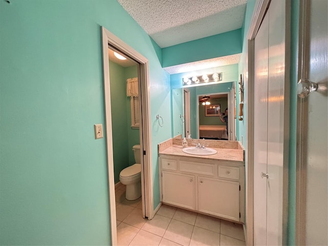 bathroom featuring tile patterned floors, a textured ceiling, ensuite bathroom, vanity, and toilet