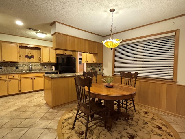 dining room with a textured ceiling, light tile patterned flooring, wainscoting, wood walls, and ornamental molding