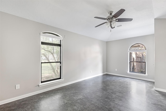 18510 Bluffview Dr, Crosby, TX 77532 - empty room featuring finished concrete flooring, baseboards, a ceiling fan, and a wealth of natural light