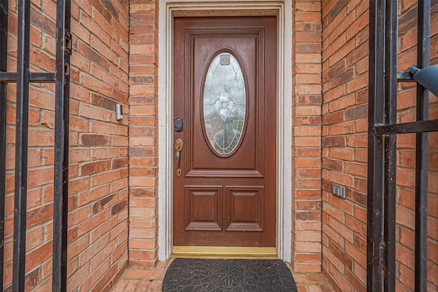 doorway to property featuring brick siding