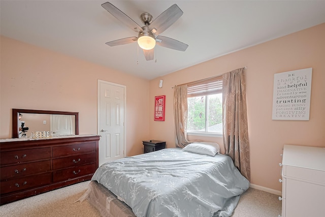 bedroom with baseboards, ceiling fan, and light carpet