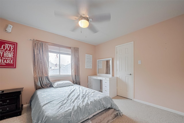 bedroom with a ceiling fan, light carpet, and baseboards