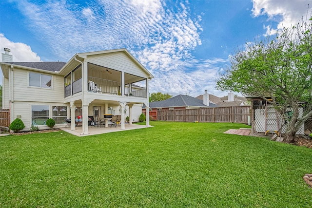 back of property with a fenced backyard, a balcony, a ceiling fan, a yard, and a patio area