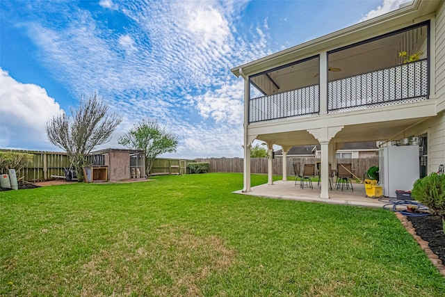 view of yard featuring a balcony, a fenced backyard, and a patio area