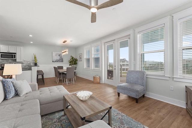 4131 Pointe W Dr Unit 203, Galveston, TX 77554 - living room with healthy amount of natural light, light wood-style floors, a chandelier, baseboards, and recessed lighting