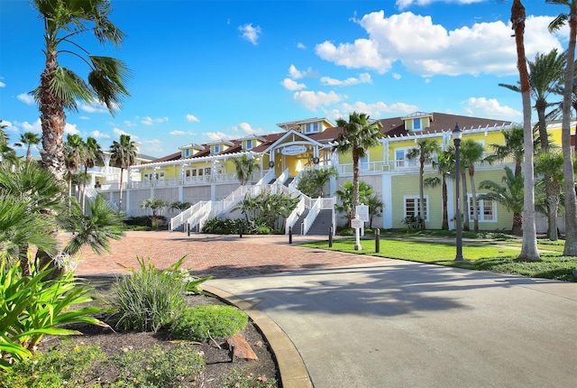4131 Pointe W Dr Unit 203, Galveston, TX 77554 - view of front of property featuring stairway, a porch, a residential view, and a front yard