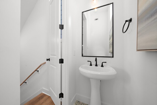 bathroom with a sink, baseboards, and wood finished floors