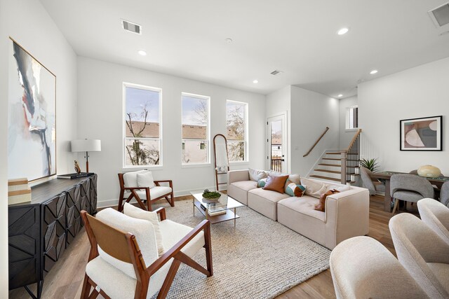 living room with stairs, recessed lighting, light wood finished floors, and visible vents