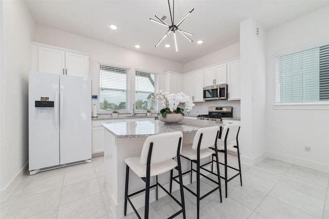 15115 Parkland Canyon Dr, Cypress, TX 77433 - kitchen with appliances with stainless steel finishes, decorative backsplash, white cabinets, a center island, and recessed lighting