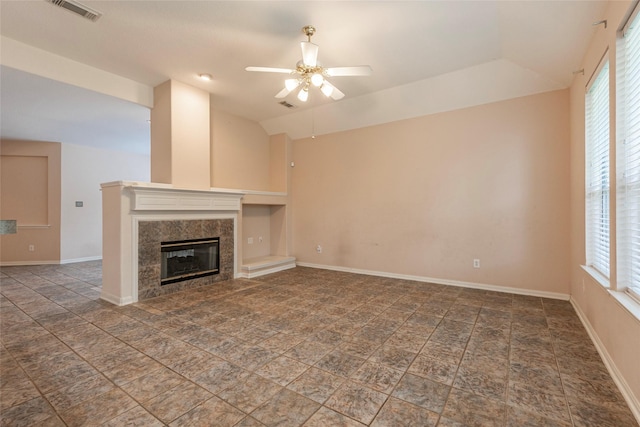 unfurnished living room with lofted ceiling, baseboards, ceiling fan, a high end fireplace, and visible vents