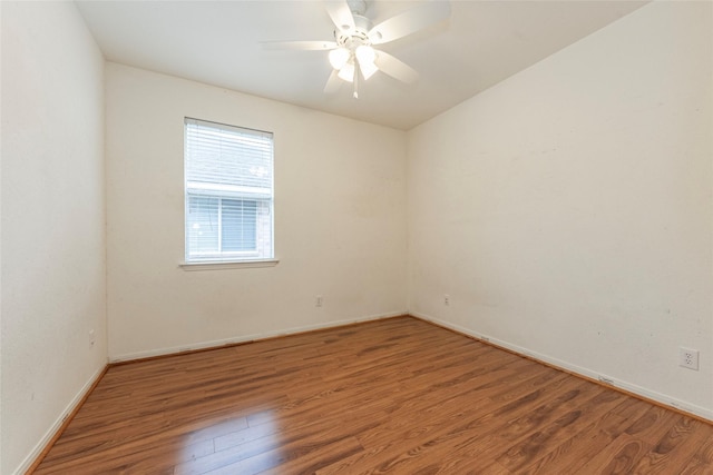 spare room featuring baseboards, ceiling fan, and wood finished floors