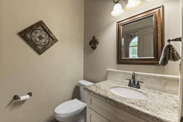 bathroom featuring decorative backsplash, vanity, and toilet