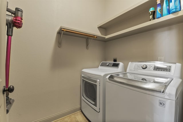laundry area with washing machine and dryer, baseboards, and laundry area