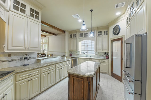 kitchen with appliances with stainless steel finishes, a sink, visible vents, and plenty of natural light