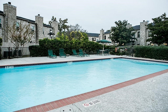community pool featuring a patio area and fence