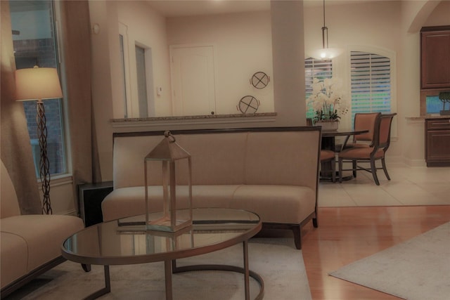 living area featuring light wood finished floors and arched walkways