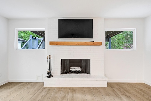 room details with baseboards, a brick fireplace, and wood finished floors