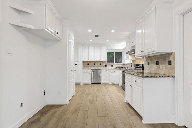 kitchen featuring appliances with stainless steel finishes, decorative backsplash, light wood-style flooring, and white cabinetry