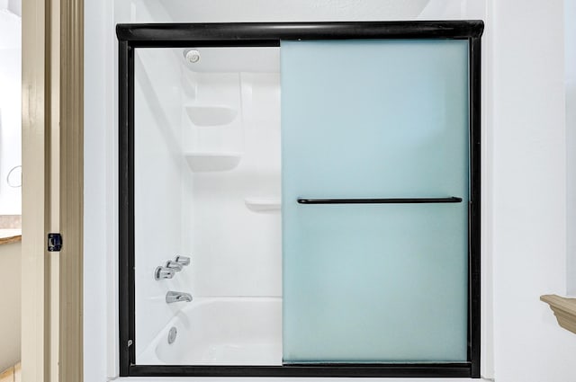 bathroom featuring bath / shower combo with glass door