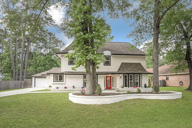 view of front of home with fence, a shingled roof, concrete driveway, and a front yard