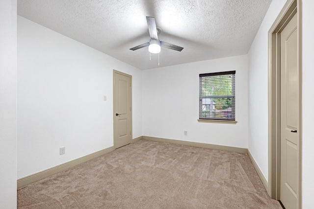unfurnished bedroom with carpet flooring, a ceiling fan, a textured ceiling, and baseboards